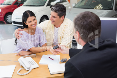 Salesman giving key to a smiling couple