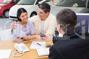 Salesman giving key to a smiling couple