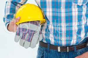 Construction worker holding hard hat and gloves