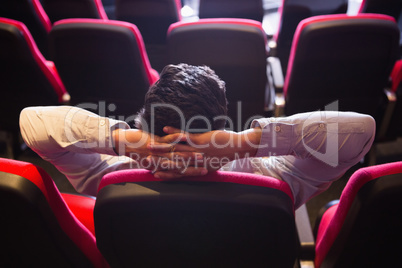 Young man with hands head watching a film