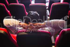 Young man with hands head watching a film