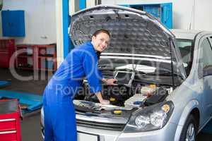 Mechanic examining under hood of car