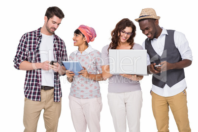 Smiling coworkers with technology interacting together