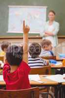 Pupil raising hand during geography lesson in classrorm