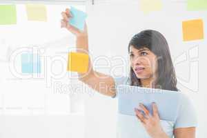 Businesswoman holding digital tablet and sticky notes