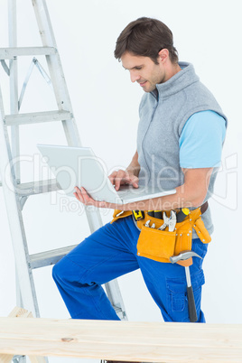 Carpenter using laptop over white background