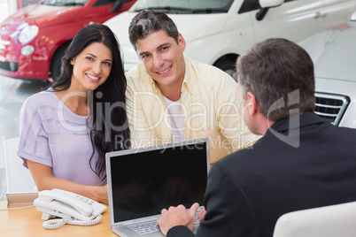 Smiling couple buying a new car