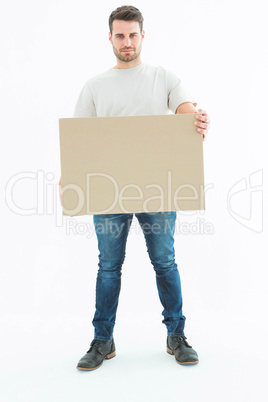 Confident delivery man carrying cardboard box