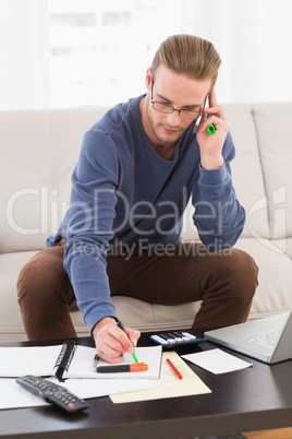 Concentrated man with glasses taking notes