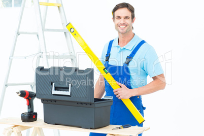 Carpenter holding spirit level at table