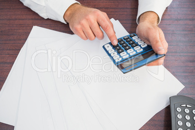 Close up of finger using calculator at desk