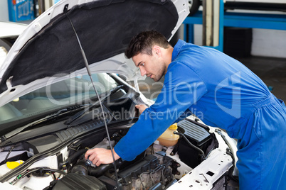 Mechanic examining under hood of car