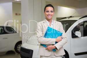 Businesswoman holding document while looking at camera