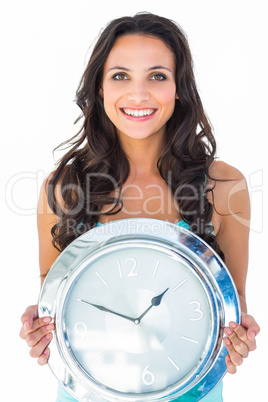 Pretty brunette holding a clock