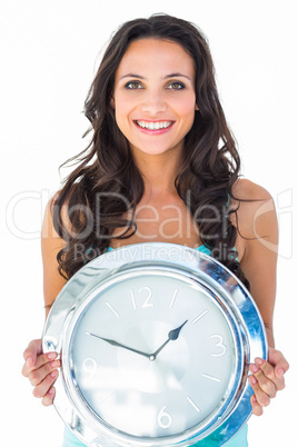 Pretty brunette holding a clock Pretty brunette holding a clock