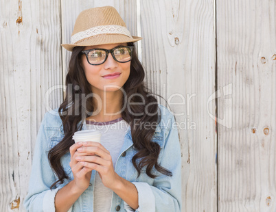 Pretty brunette holding take away coffee