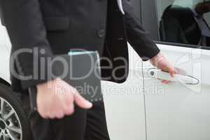 Businessman holding a car door handles
