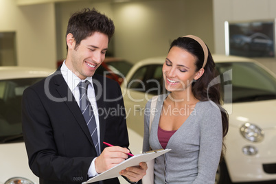 Smiling businessman undersign a car contract