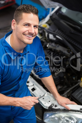Smiling mechanic looking up at camera