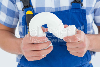 Plumber holding sink pipe on white background