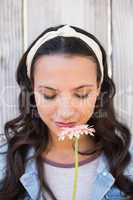 Pretty hipster smelling a flower