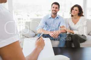 Reconciled couple smiling and talking with their therapist