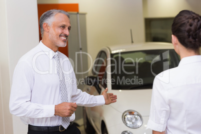 Businessman showing a car to a woman