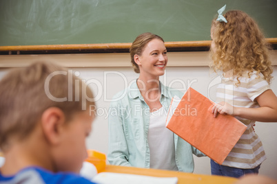 Cute pupil looking her teacher during class presentation