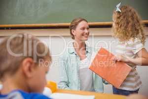 Cute pupil looking her teacher during class presentation