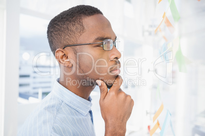 Thoughtful businessman reading sticky notes