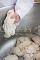 Close up of baker preparing dough in industrial mixer