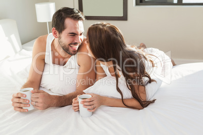 Young couple having coffee in bed