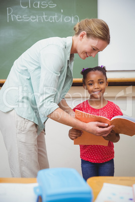 Cute pupil smiling at camera during class presentation