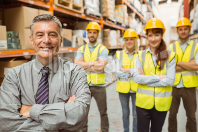 Smiling warehouse team with arms crossed