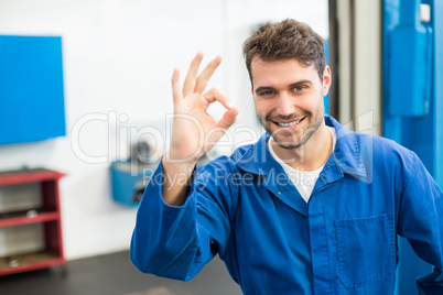 Smiling mechanic showing ok sign