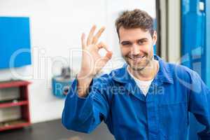 Smiling mechanic showing ok sign