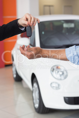 Businessman giving car key to customer