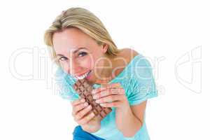 Pretty blonde eating bar of chocolate