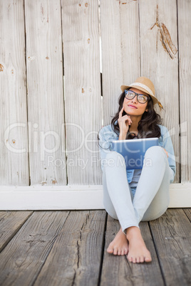 Pretty hipster sitting on ground with tablet