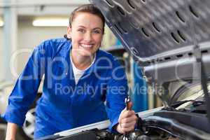 Smiling mechanic fixing car engine