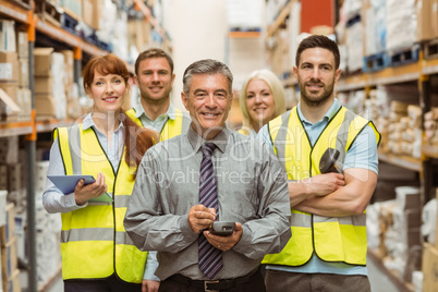 Smiling warehouse team with arms crossed