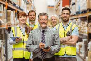 Smiling warehouse team with arms crossed
