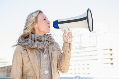 Smiling blonde speaking on megaphone