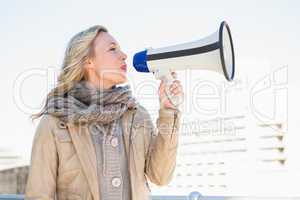 Smiling blonde speaking on megaphone