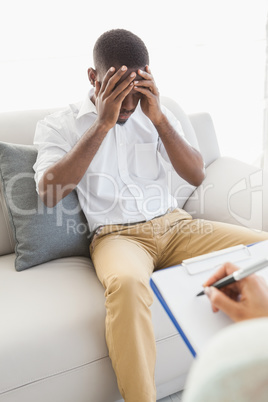 Therapist taking notes on her upset patient