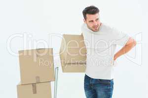 Delivery man with cardboard boxes suffering from backach