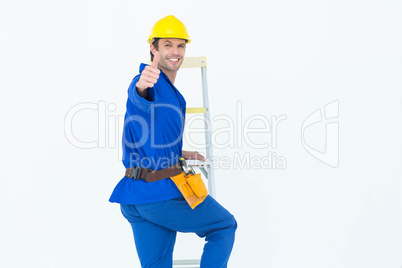 Repairman gesturing thumbs up while climbing step ladder