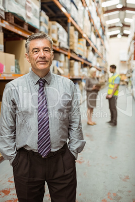 Cheerful businessman with hands in pocket posing