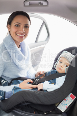 Mother securing her baby in the car seat