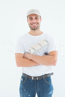 Happy man with paint roller standing arms crossed Happy man with paint roller standing arms crossed